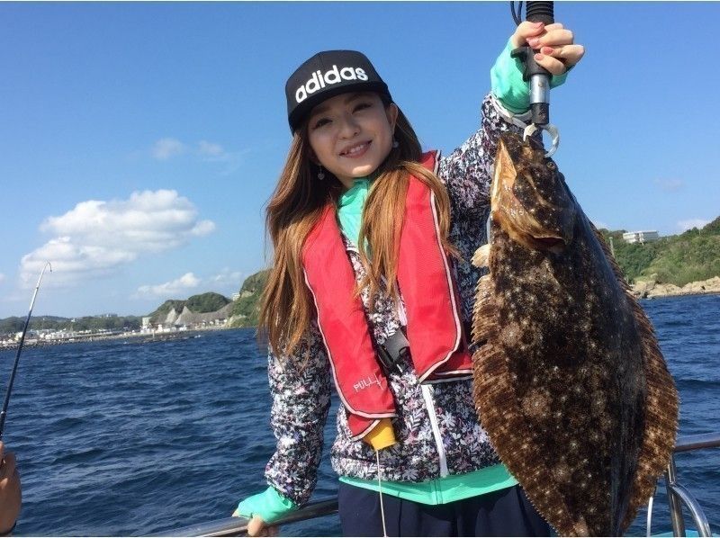 A woman smiling after catching a large flounder