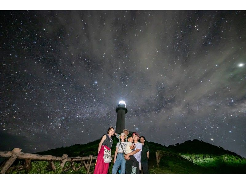 ครอบครัวที่ถ่ายภาพภายใต้ท้องฟ้าที่เต็มไปด้วยดวงดาวและประภาคารของ Ishigaki Island Field Nature Ishigaki Island