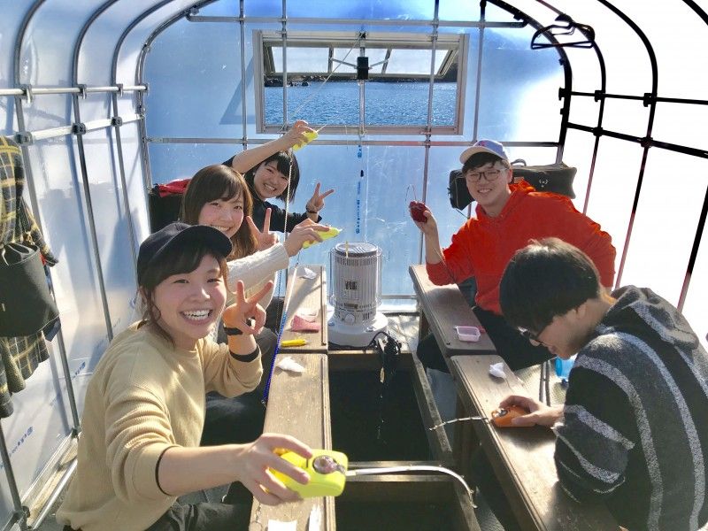 A group of young people enjoying smelt fishing in a dome boat