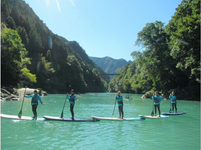 コンセプトの奥多摩・白丸湖でのSUP(サップ)体験を楽しむ人々