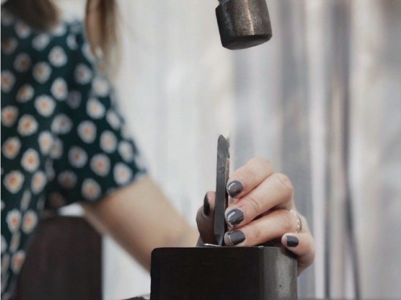 A woman trying out making a bangle with "dywf"