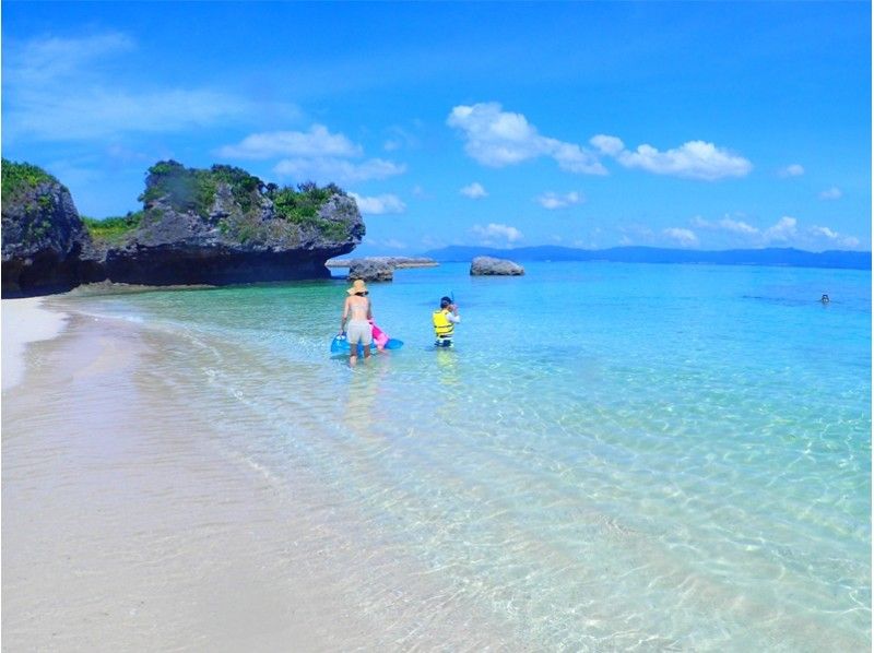 ผู้ปกครองและเด็กเพลิดเพลินกับการดำน้ำตื้นบนชายหาดของเกาะ Panari เกาะ Aragusuku