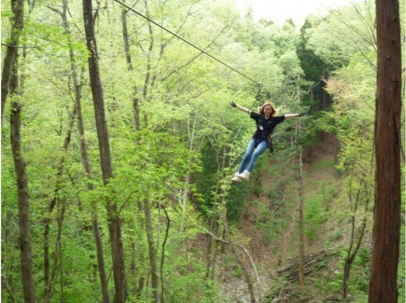 ผู้หญิงกำลังเพลิดเพลินกับซิปสไลเดอร์ Forest Adventure Chiba