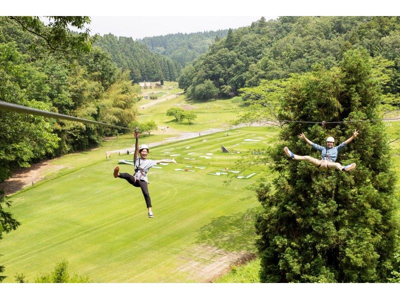 Couple enjoying long zip slide Forest Adventure Tarzania