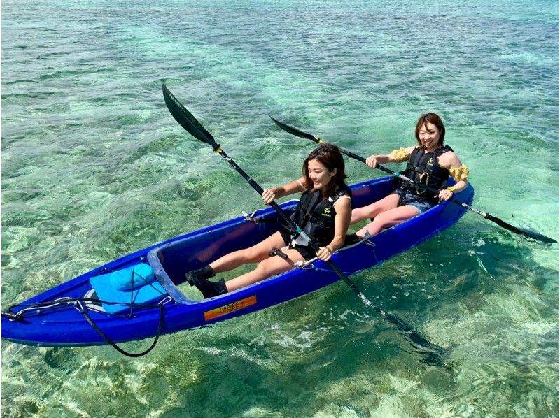 A woman enjoying a clear kayak tour of Sesoko Island organized by Okinawa Marine Studio