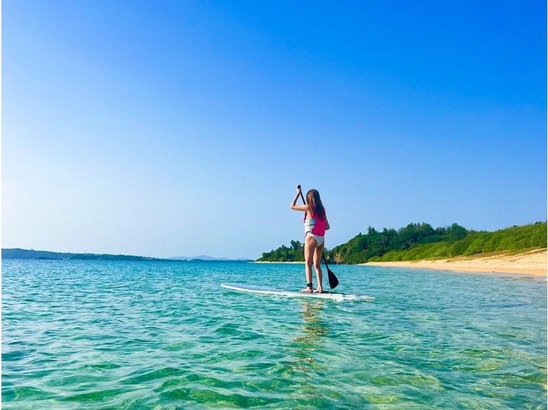 A woman enjoying SUP (stand-up paddle board) on Tsuken Island, organized by DREAM OCEAN Okinawa