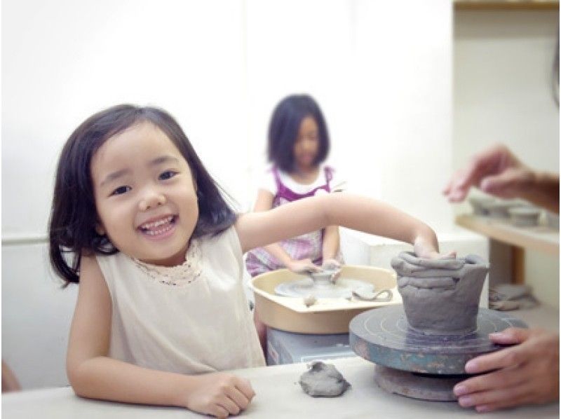 Children enjoying pottery experience Hand forming potter's wheel