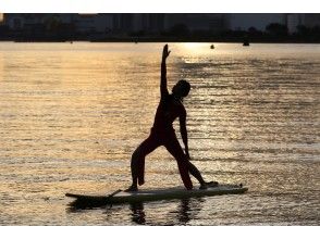 プランの魅力 夕焼けの海をバックにヨガ の画像