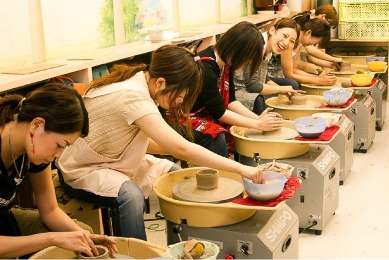 人們享受陶藝課和電動陶輪