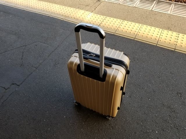 駅のホームに置かれたスーツケース