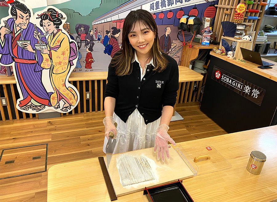 A woman enjoying the soba making experience at "SOBAGIRI Rakujo = Ramen Soba Making =" in Asakusa Kappabashi