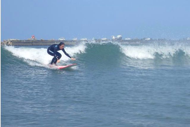 HAPPY　SURF(ハッピーサーフ)のサーフィン体験をする女性