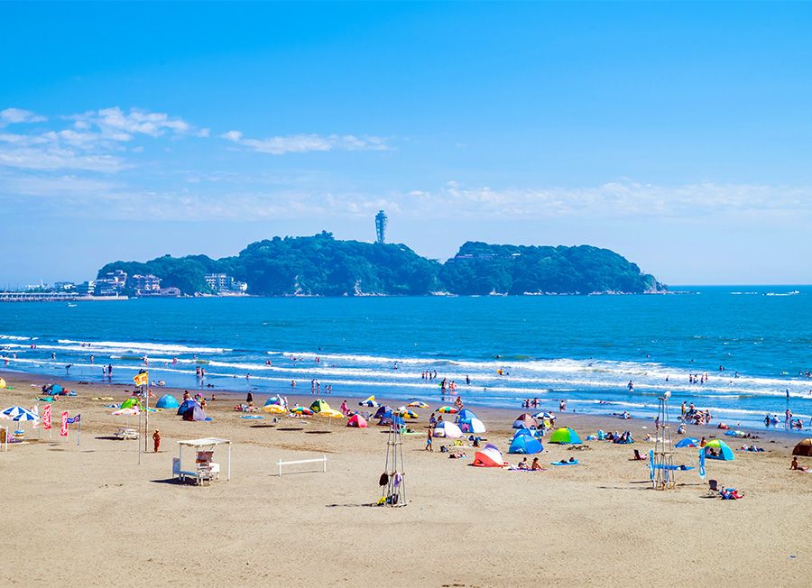 江ノ電観光スポット　江ノ島電鉄　片瀬西浜海岸　江ノ島駅　江ノ島を望む人気ビーチ　テントやパラソルで賑わう夏