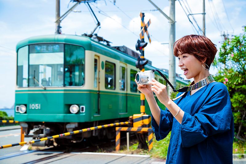 Enoden Enoshima Electric Railway ผู้หญิงกำลังถ่ายรูป Enoden และทะเล