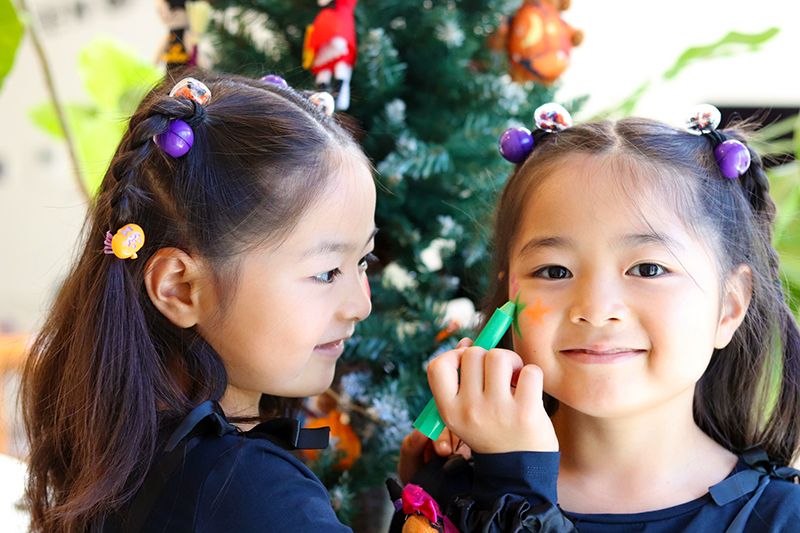 2023 年东京萬聖節活動現場，兒童女孩們在萬聖節服裝圖像上畫自己的臉