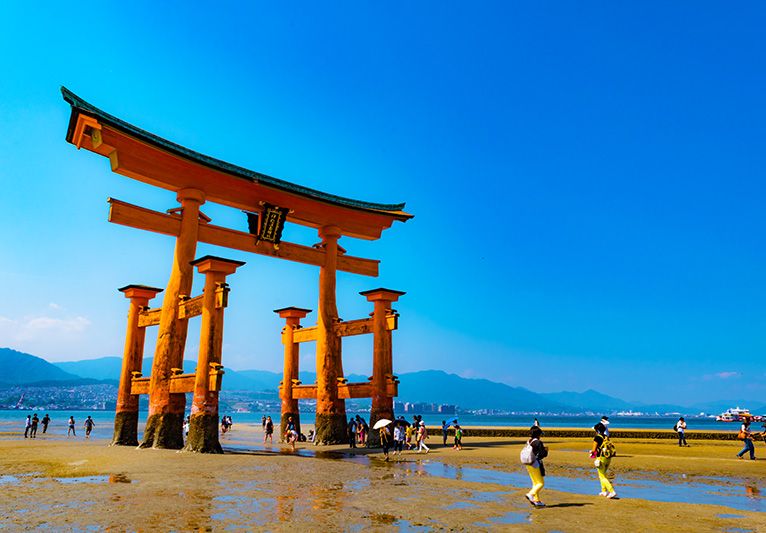 미야지마 이쓰쿠시마 신사 붉은 주홍색 오토리이 간조시 걷고 산책하는 관광객