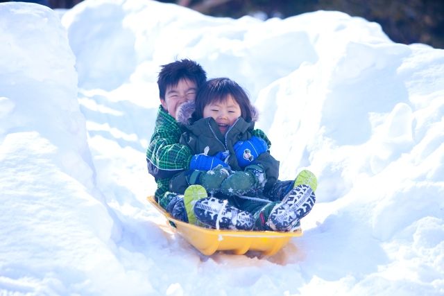 雪遊びを楽しむ子供　ソリ遊び