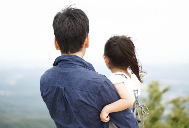 Back view of a man holding a girl