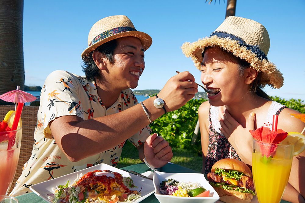 古宇利島の美味しいご飯を満喫しよう　古宇利島で楽しげにご飯を食べるカップル　イメージ