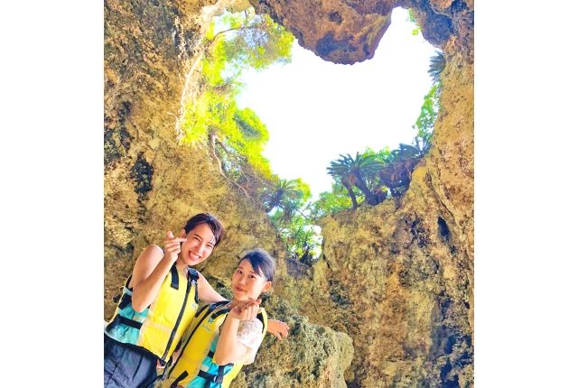 A woman enjoying a heart-shaped cave tour on Kouri Island, organized by the COCONUTS CLUB