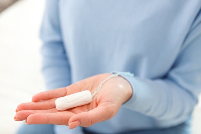 手のひらにタンポンを乗せている女性