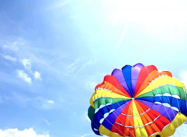 青い空の下パラセーリングを楽しむ