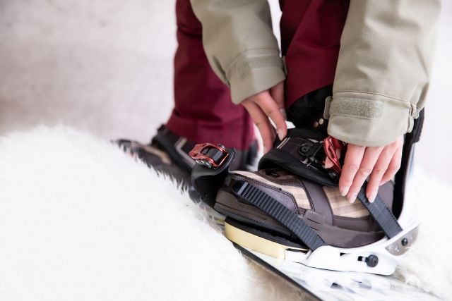 A person wearing a snowboard on their feet at a ski resort