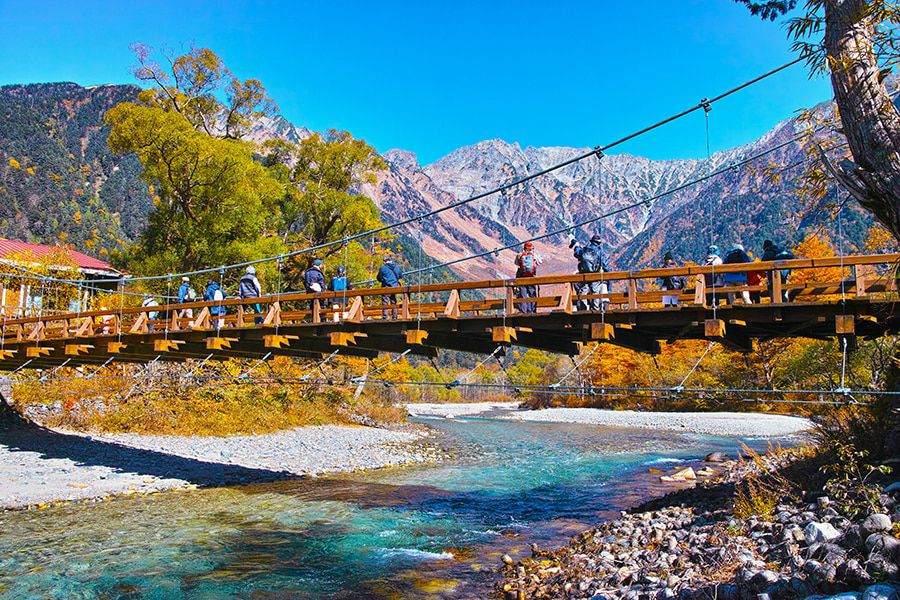 Nagano Autumn Sightseeing spot Kamikochi Kappa Bridge dyed in autumn leaves Azusa River Hotaka mountain range covered in snow National special scenic spot Special natural monument People taking pictures on the bridge