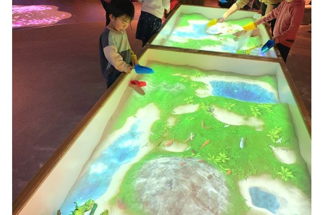 Children enjoying playing in the sand at Little Planet DiverCity Tokyo Plaza