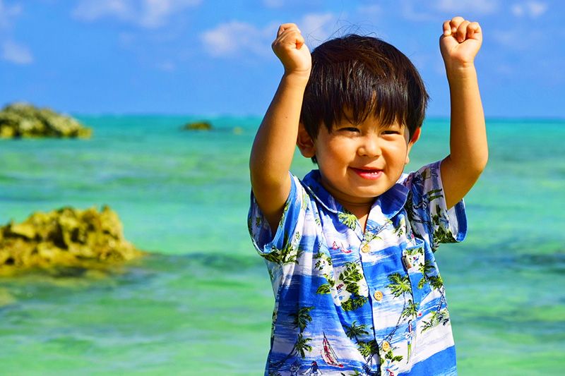 沖縄　ここは行っとけ！　冬や子供におすすめのスポット　海で遊ぶかりゆしウェアの男の子