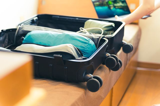 旅行準備でスーツケースの荷物を整理する人