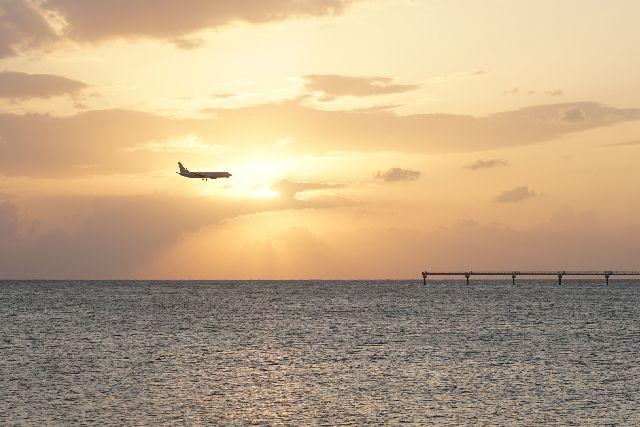 東シナ海に沈む夕陽と那覇空港へ続く進入灯