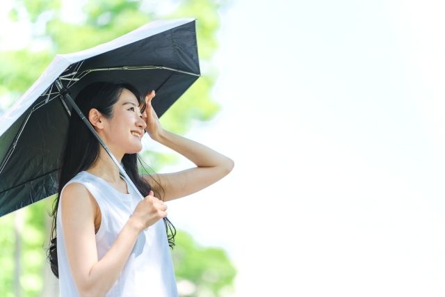 A woman holding a parasol to prevent heat stroke