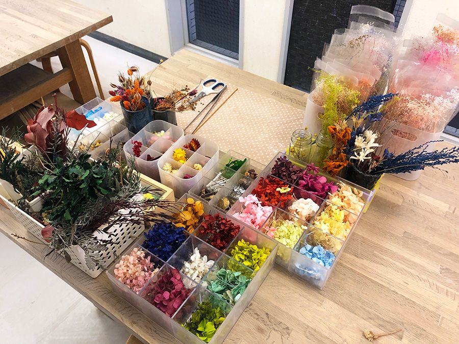 中目黒　千秋工房　ハーバリウム体験　テーブルに置かれた色とりどりの花々　素材　材料　カラフルな飾り　貝殻　花　木　葉　実　ツタ