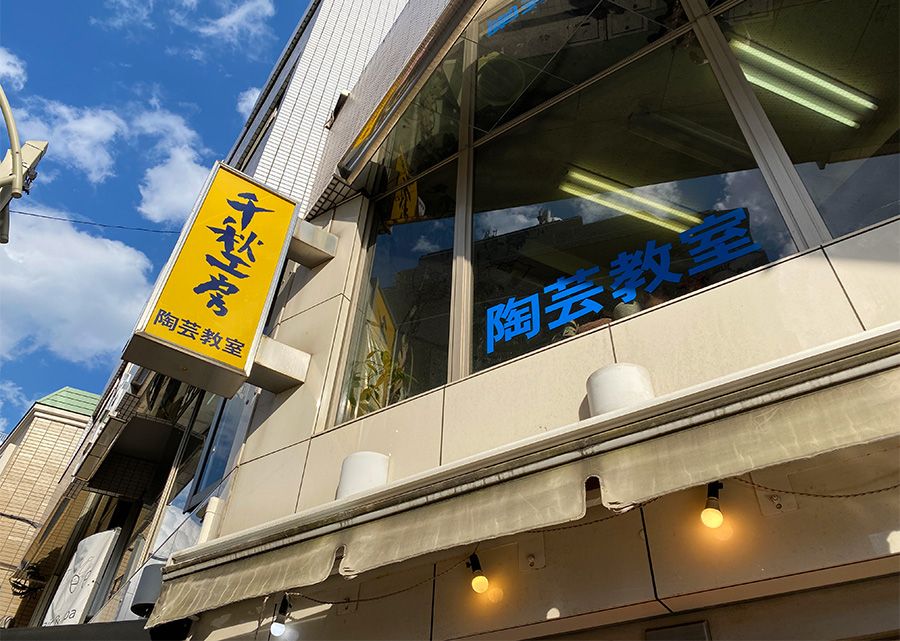 การเข้าถึงป้าย Chiaki Studio สีเหลือง มีคำว่า "Ceramics Class" เขียนอยู่บนหน้าต่าง