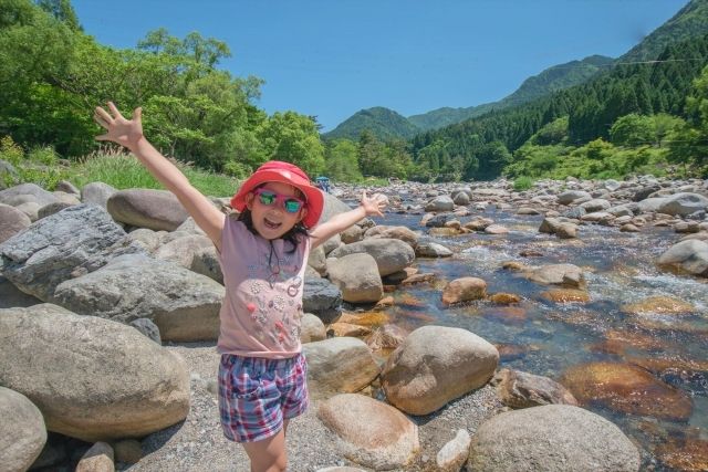 Girl enjoying playing in the river during summer vacation