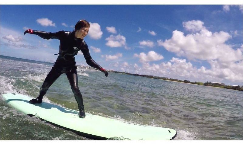 冬に沖縄ハイビサーフィンスクールにてサーフィンを楽しむ女性