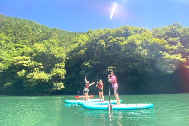 ผู้หญิงเพลิดเพลินกับประสบการณ์ SUP ใน Okutama (ทะเลสาบ Shiromaru) ซึ่งสนับสนุนโดย CRUSOE RAFTING