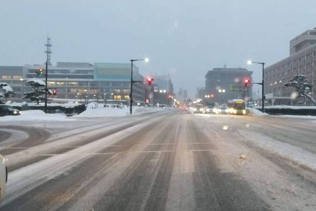 秋田県・雪の日の道路からの町並み